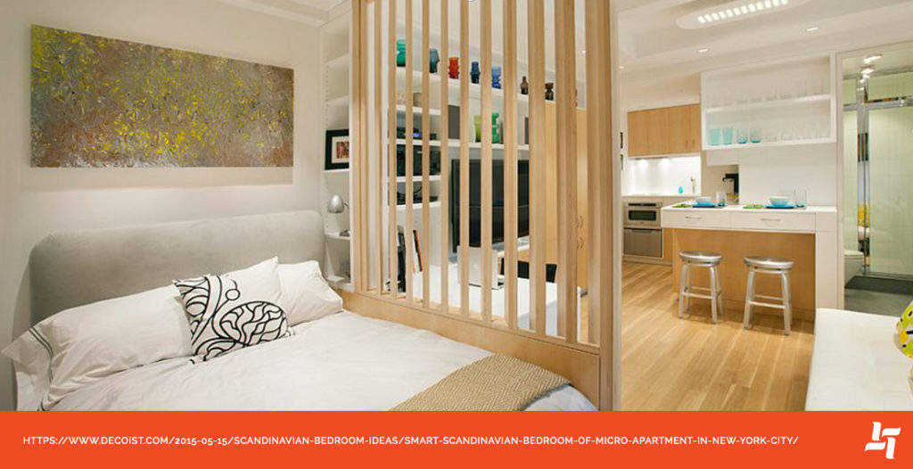 Small bachelor apartment with light wood divider separating the bed frame from rest of room. Open airy concept